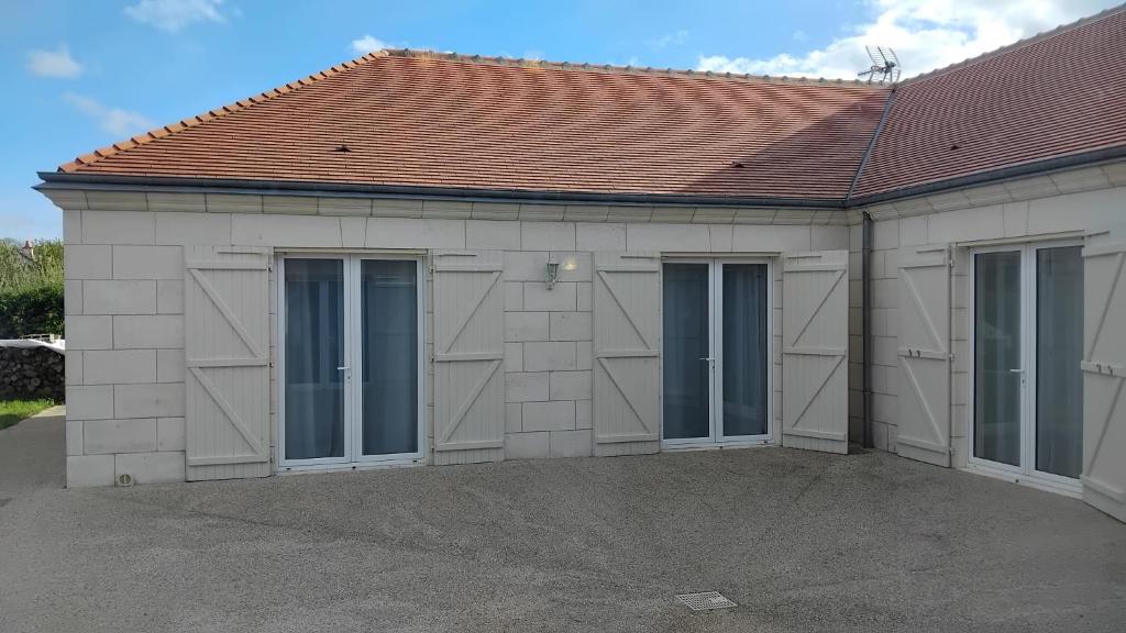 un bâtiment avec quatre portes et un toit rouge dans l'établissement Belle Maison à MESLAND, à Mesland