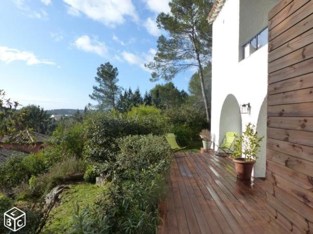 une terrasse en bois avec des chaises sur une maison dans l'établissement Independent studio st Clement of rivers 5 mn montpellier, à Saint-Clément-de-Rivière