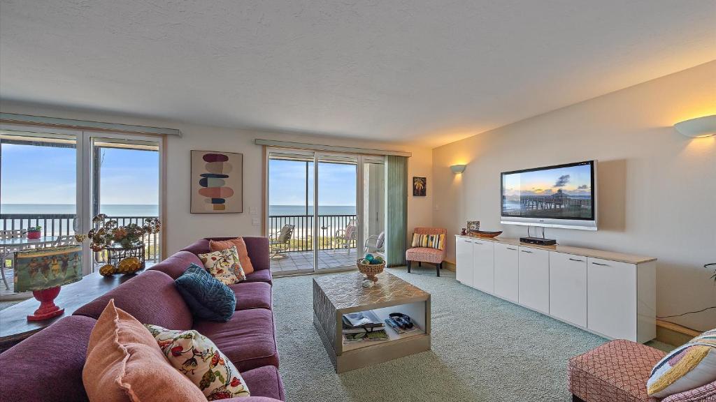 a living room with a couch and a flat screen tv at Gulf View Escape in Siesta Key