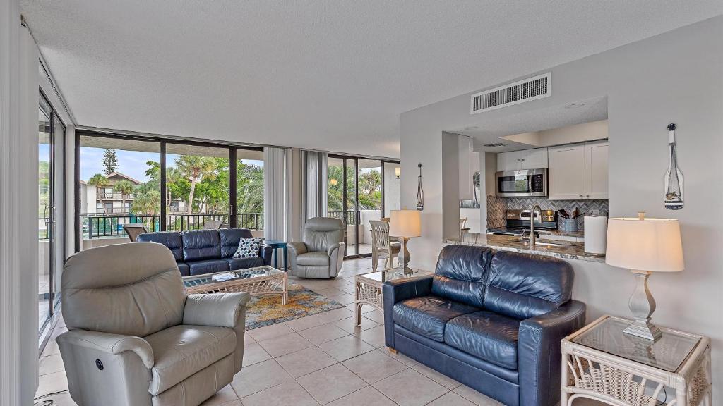 Hawks Sea Nest في سيستا كي: غرفة معيشة مع أريكة وكراسي ومطبخ