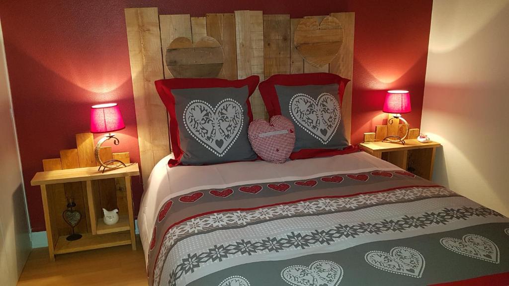 - une chambre avec un lit aux murs rouges et 2 lampes dans l'établissement Le Meix du Lac 3 étoiles - 200 m du lac - 50 m navette ski, à Gérardmer
