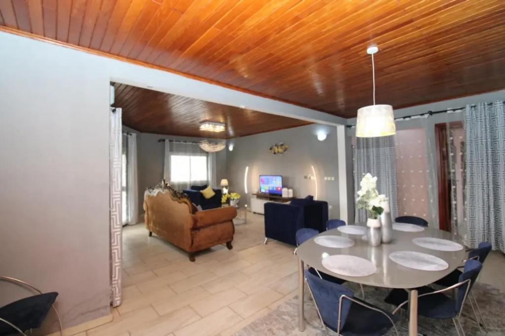 a living room with a table and a couch at RJS Appart Homey1 avec Jacuzzi in Douala