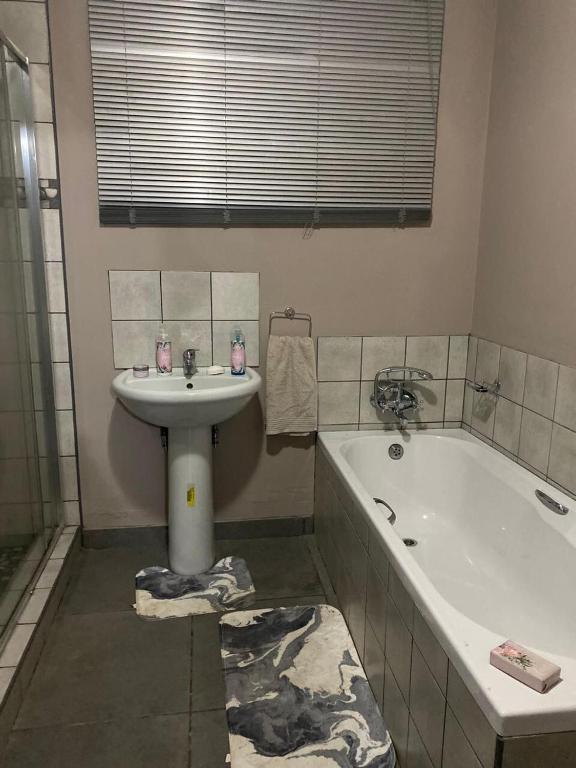 a bathroom with a sink and a bath tub at Taylor's Nest in Mancana