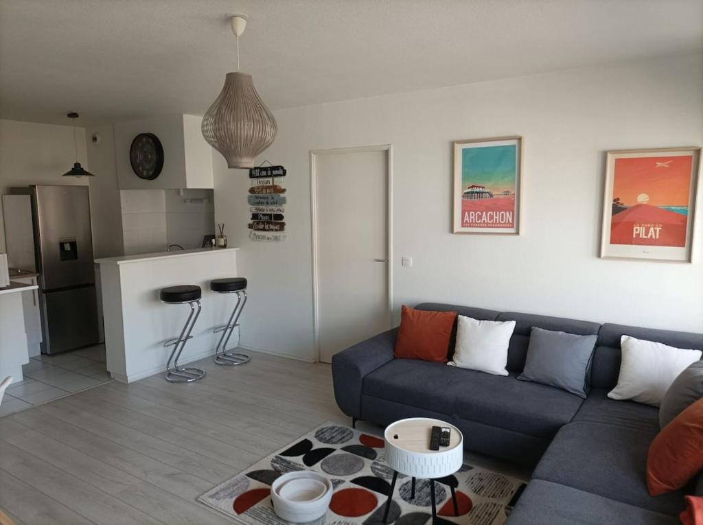 un salon avec un canapé bleu et une cuisine dans l'établissement Family cocoon in Arcachon center, à Arcachon