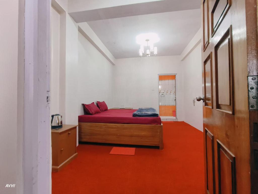 a bedroom with a bed and a red floor at Kinley Homestay in Darjeeling