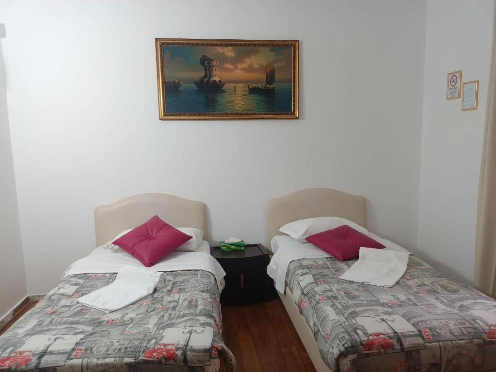 two beds in a room with a picture on the wall at Niam House Volturno in Rome