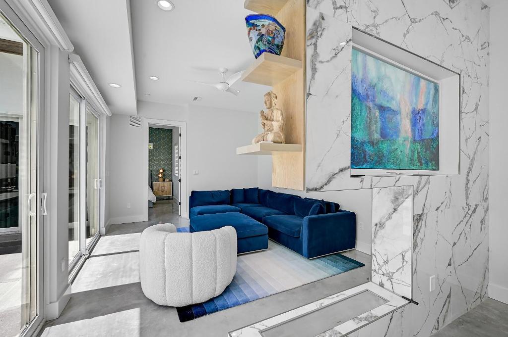 a living room with a blue couch and a painting at Paradise Found in Sarasota
