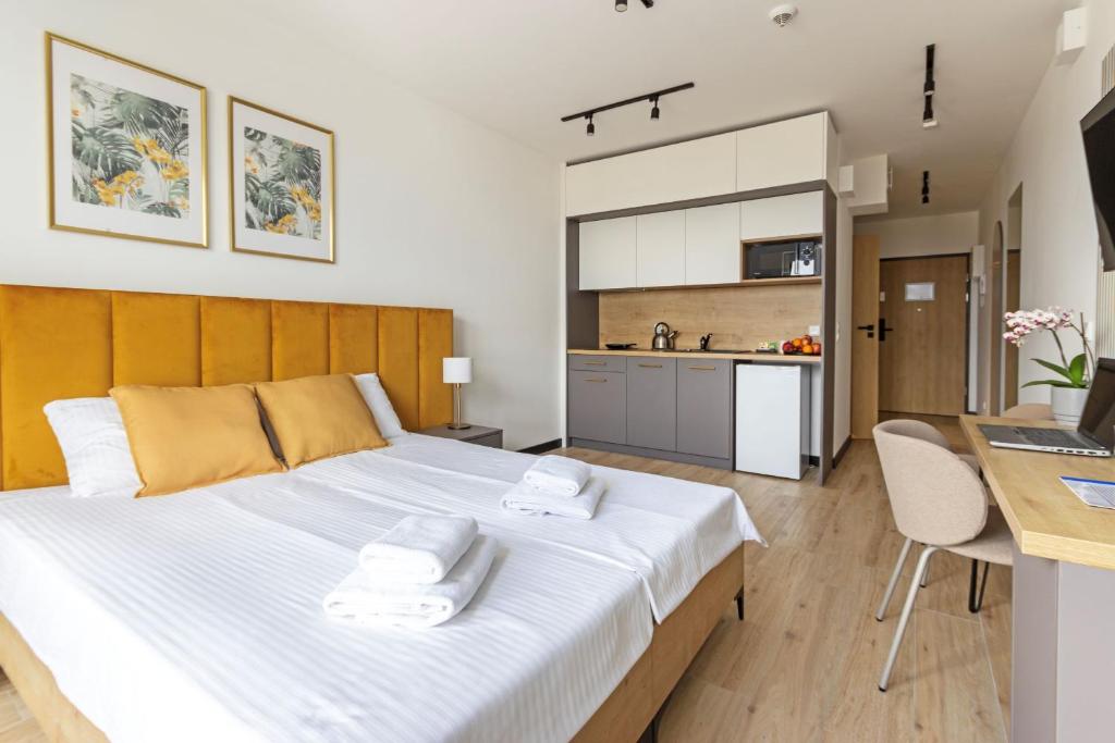 a bedroom with a large bed and a kitchen at Zeus Apartments Lublin in Lublin