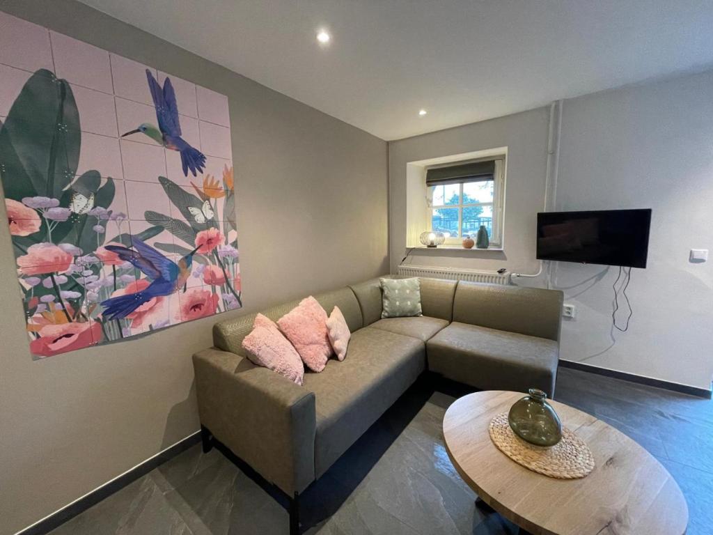 a living room with a couch and a table at Cosy Holliday Home for 3 persons in Voerendaal