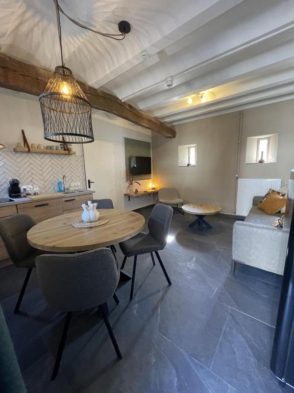 a living room with a table and chairs and a couch at 18 4p Authentic Cosy Cottage in Voerendaal