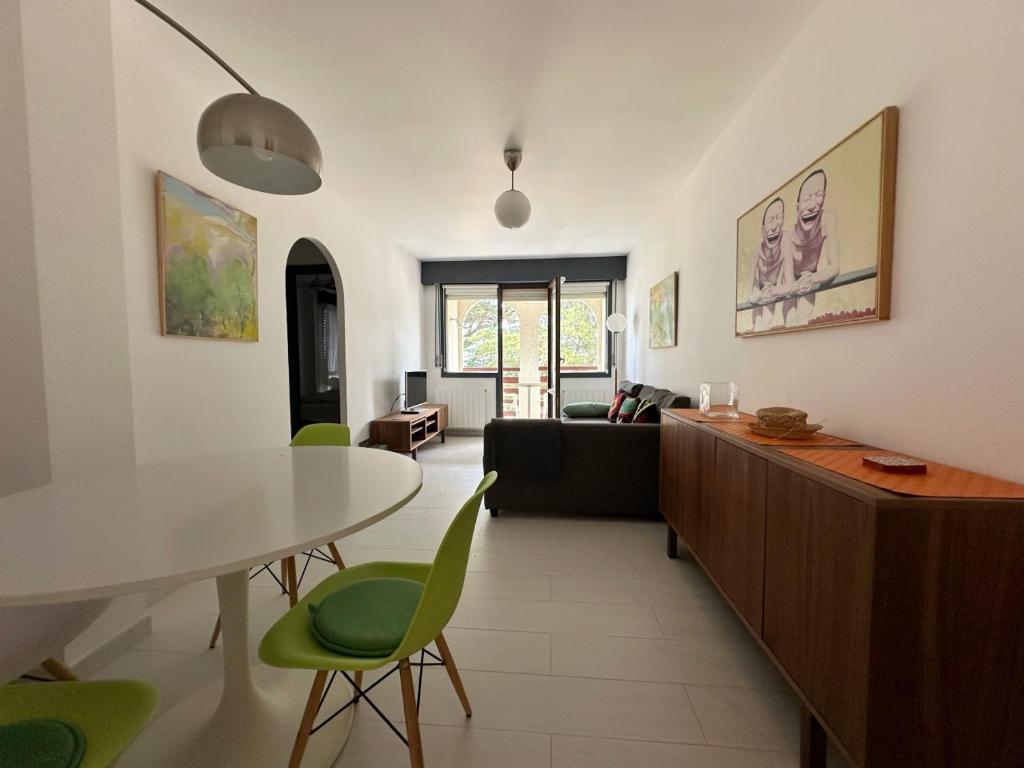 a living room with a table and green chairs at Maralfrente de Noja- 6020 in Noja