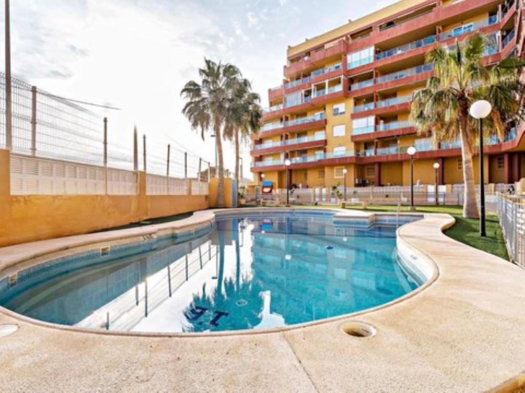 a swimming pool in front of a building at Roquetas "Estudio acogedor cerca del Castillo y del puerto de Roquetas, aireconditionado" in Roquetas de Mar