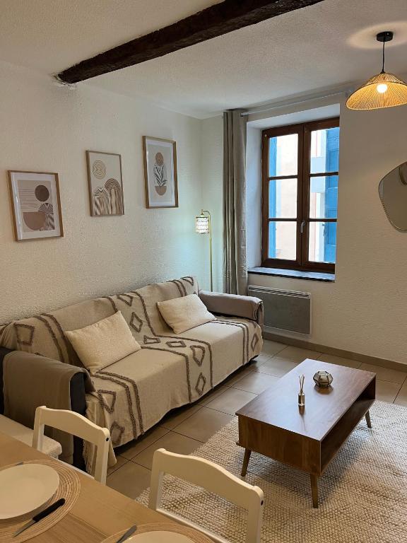 un salon avec un canapé et une table dans l'établissement Loft Bohème & cosy Lit King size, à Carcassonne