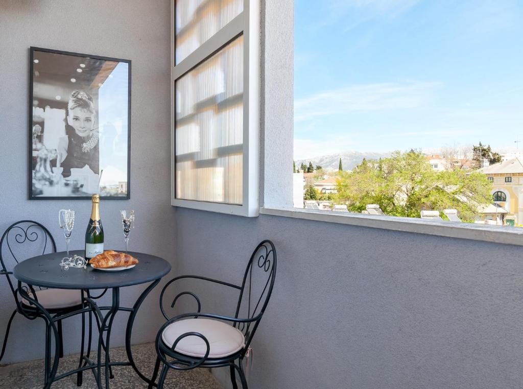 een tafel en stoelen in een kamer met een raam bij Apartment Sophie’s place in Split