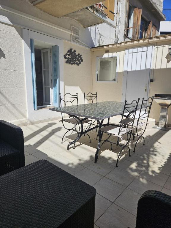une table et des chaises assises sur une terrasse dans l'établissement L'instant Roméon, à Marseille