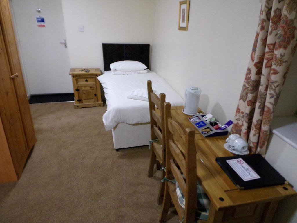 a small room with a bed and a table at The Belfry Hotel in Little Dean