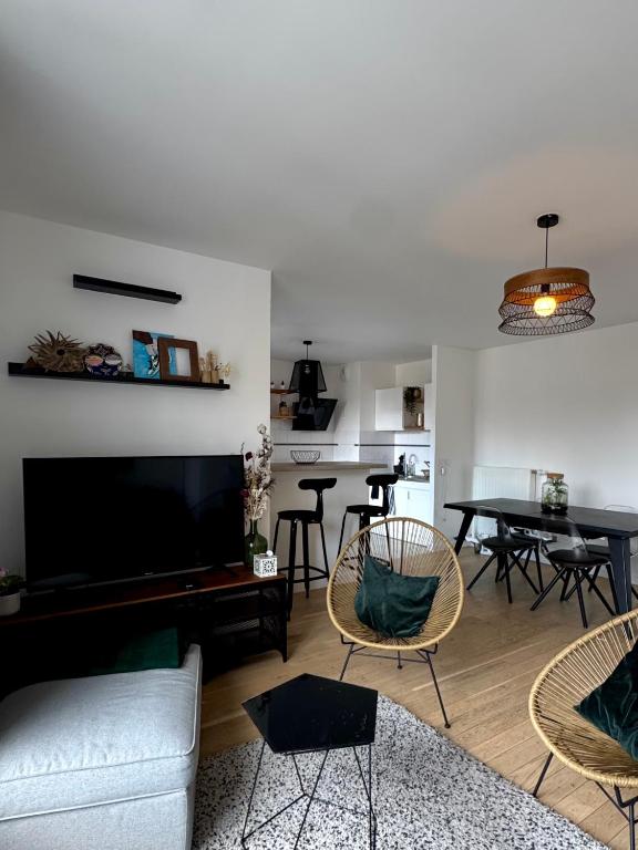 ein Wohnzimmer mit Sofa und Tisch in der Unterkunft Charmant appartement aux portes de Paris, avec Balcon et Parking in Aubervilliers