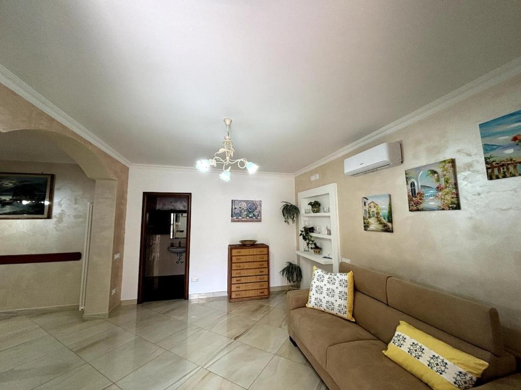 a living room with a couch and a chandelier at Da Pupa, apartment with a sea view in Vico Equense