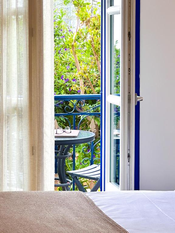 an open door to a patio with a table on a balcony at Armata Boutique Hotel in Spetses