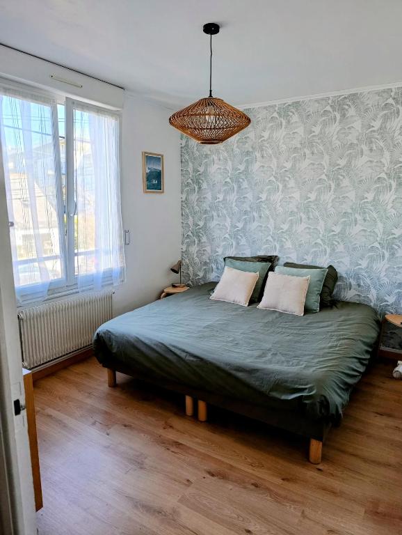 une chambre avec un lit avec une couette verte dans l'établissement Chambre privée sur Concarneau, à Concarneau