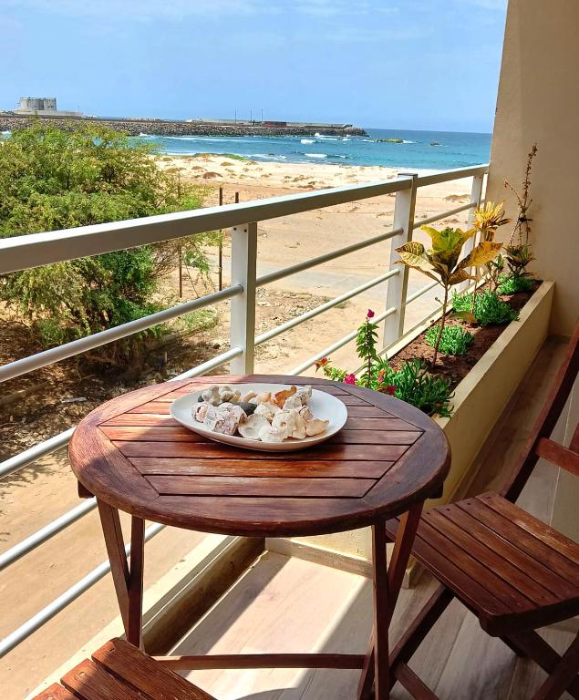 un piatto di cibo su un tavolo su un balcone con la spiaggia di Onda do Mar a Sal Rei