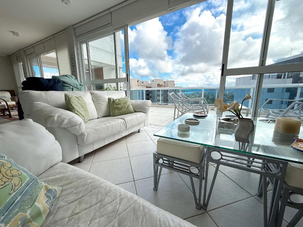 ein Wohnzimmer mit Sofa und Tisch in der Unterkunft Cobertura com Piscina Privativa e Vista Mar in Riviera de São Lourenço