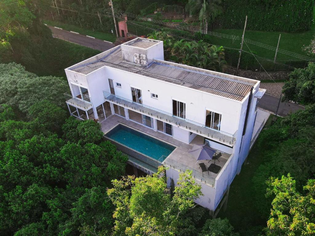 einen Blick über ein weißes Haus mit einem Pool in der Unterkunft Luxo e segurança - 30 minutos de SP in Carapicuíba