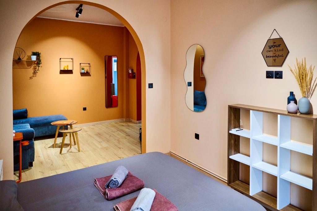 Una sala de estar con un sofá y una guitarra en la pared. en The Arch Suite, en Tesalónica