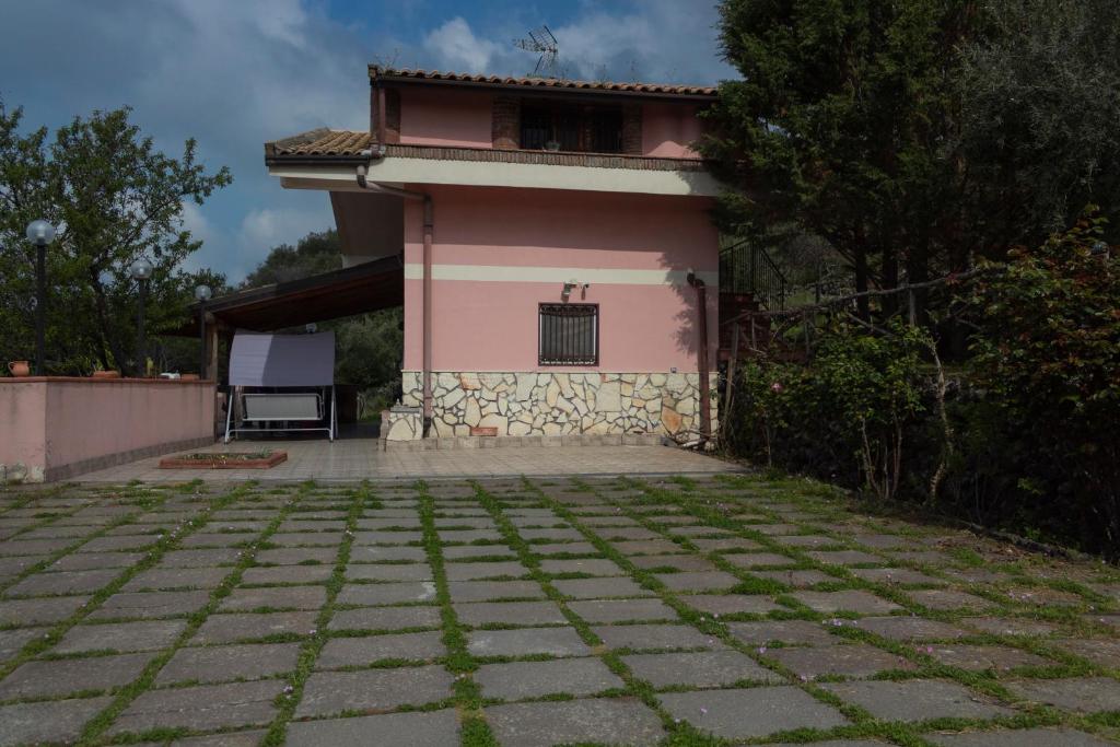 a pink house with a window on top of it at Casa vacanze Etna in Santa Maria di Licodia