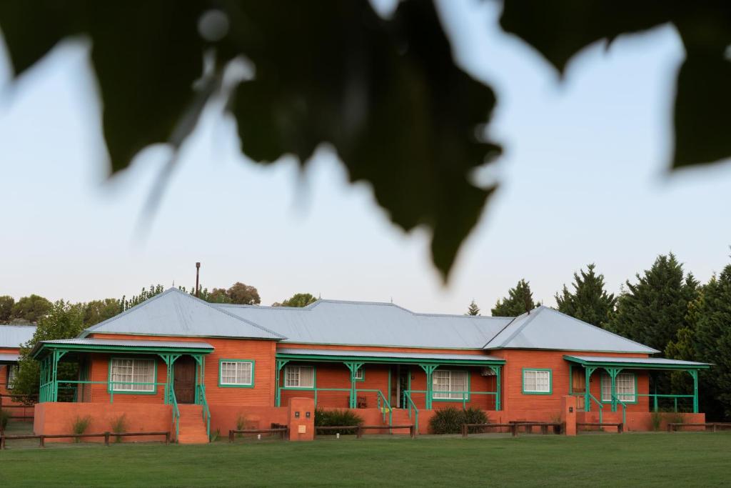 a red building with a green roof at La Toldería - Casas de Campo in Trenque Lauquen