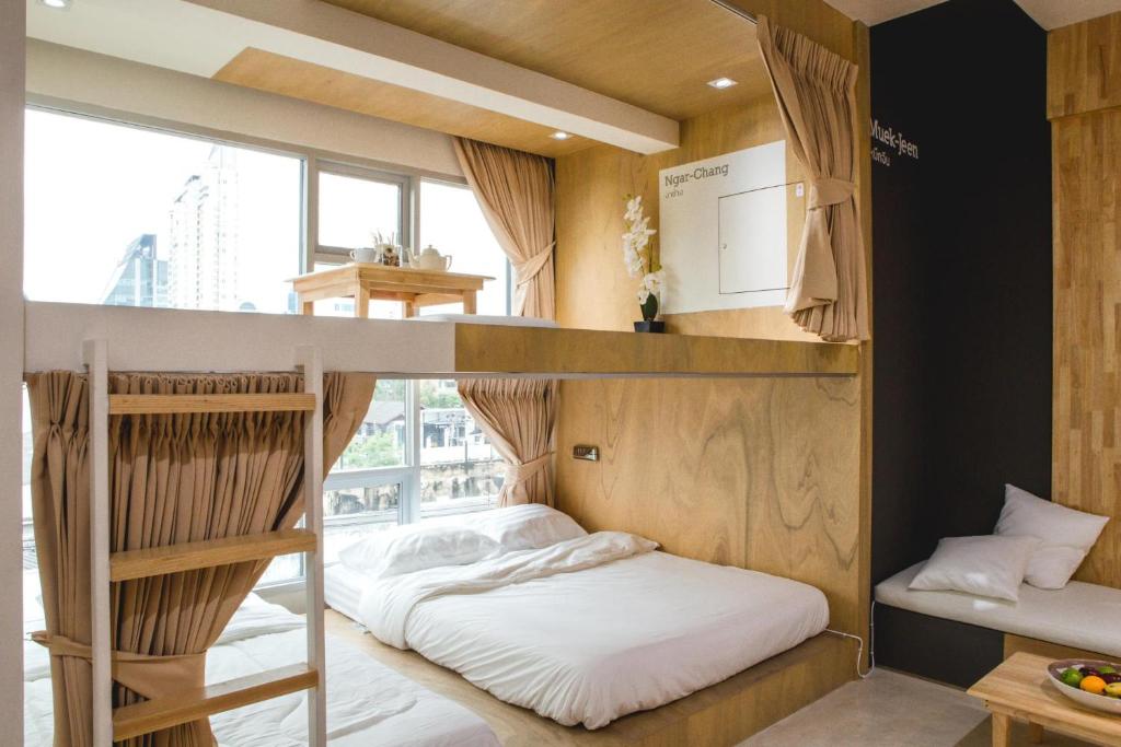 - une chambre avec des lits superposés et une grande fenêtre dans l'établissement BOB Hostel सुख सदन ひだまり庵 파란달여관, à Bangkok