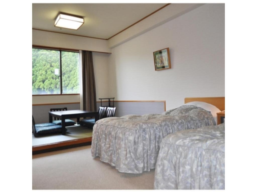 une chambre d'hôtel avec deux lits et une table dans l'établissement Hotel Tetora Resort Tateyama Kokusai - Vacation STAY 55690v, à Tateyama