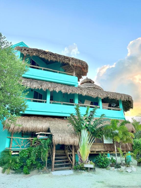a hotel on the beach with a thatched building at Shipwreck Cove in Caye Caulker