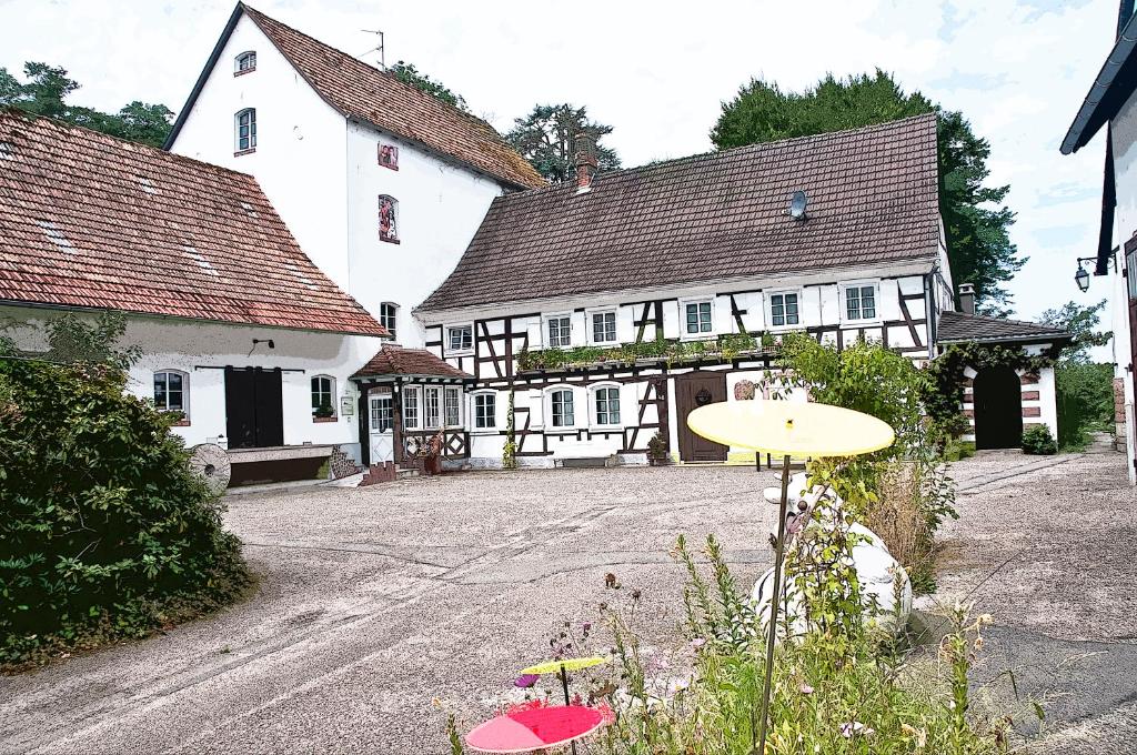 Un edificio con dos sombrillas en medio de una calle. en Moulin de Schwabwiller, en Schwabwiller