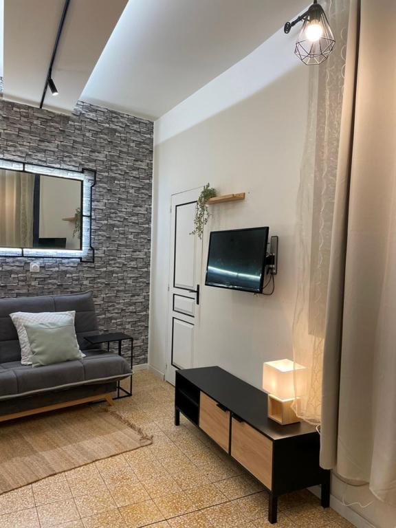 un salon avec un canapé et une télévision dans l'établissement Studio Nîmes, 6 rue Nationale, à Nîmes