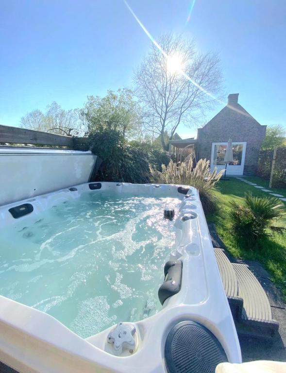 a jacuzzi tub in the backyard of a house at Huisje Suus, inclusief jacuzzi, kano en kajak in Zuid-Scharwoude