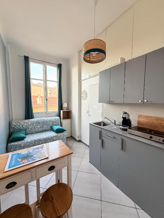 - une cuisine avec un canapé et une table dans une chambre dans l'établissement PORT - Charmant Studio, à Nice