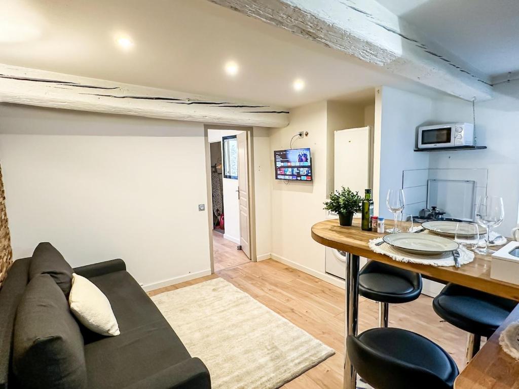 a living room with a couch and a table at Charming Flat in the Historic Center of Saint-Rémy in Saint-Rémy-de-Provence