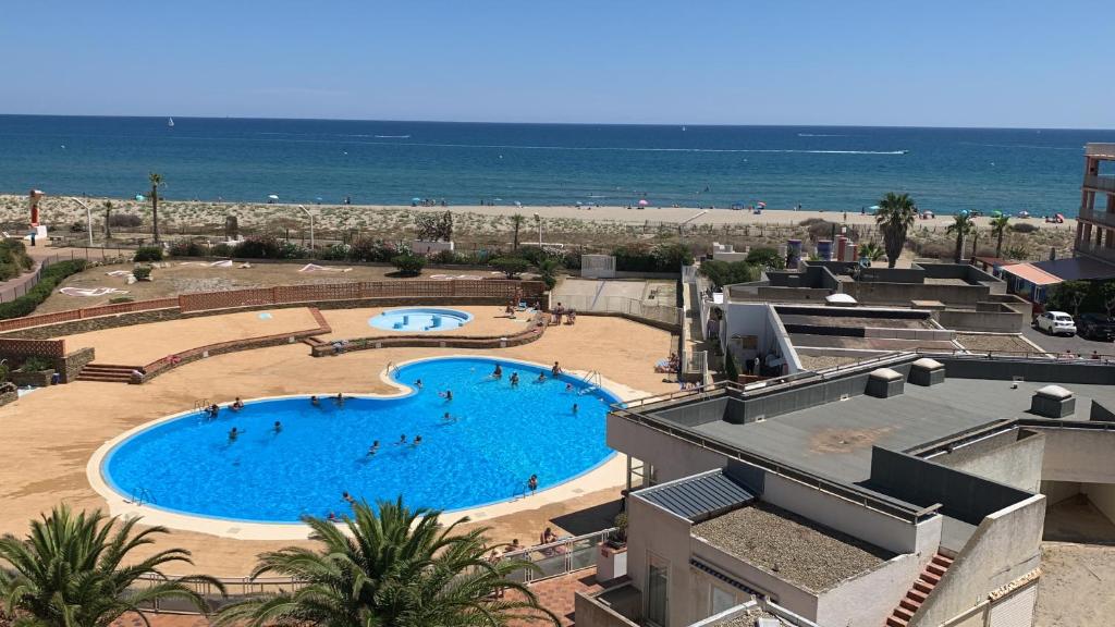 una gran piscina junto a una playa en Les pieds dans l eau au Lydia Playa, en Le Barcarès