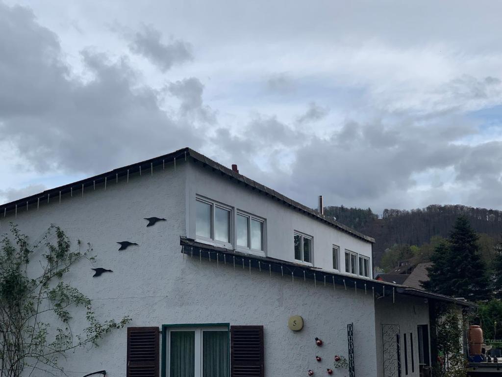 une maison blanche avec des oiseaux sur son côté dans l'établissement Rosenstufen, à Heimbach