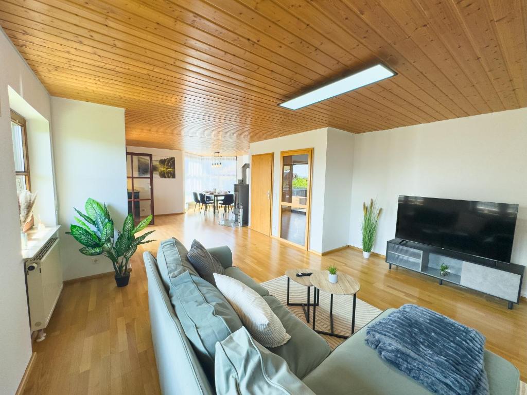 a living room with a couch and a flat screen tv at Moderne Luxus-Oase in Gailingen mit Garten, 2 Balkone, Nähe Bodensee & Rheinfall in Gailingen