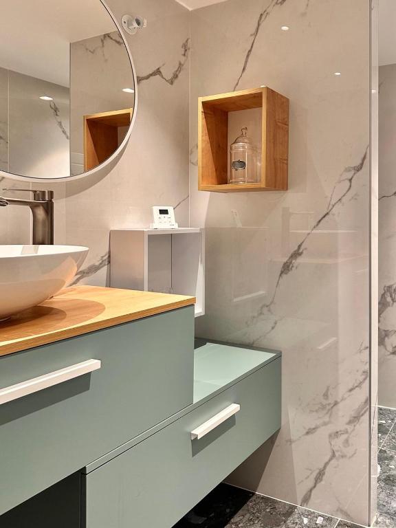a bathroom with a sink and a mirror at Le Clos de la Côte Sauvage in Piriac-sur-Mer