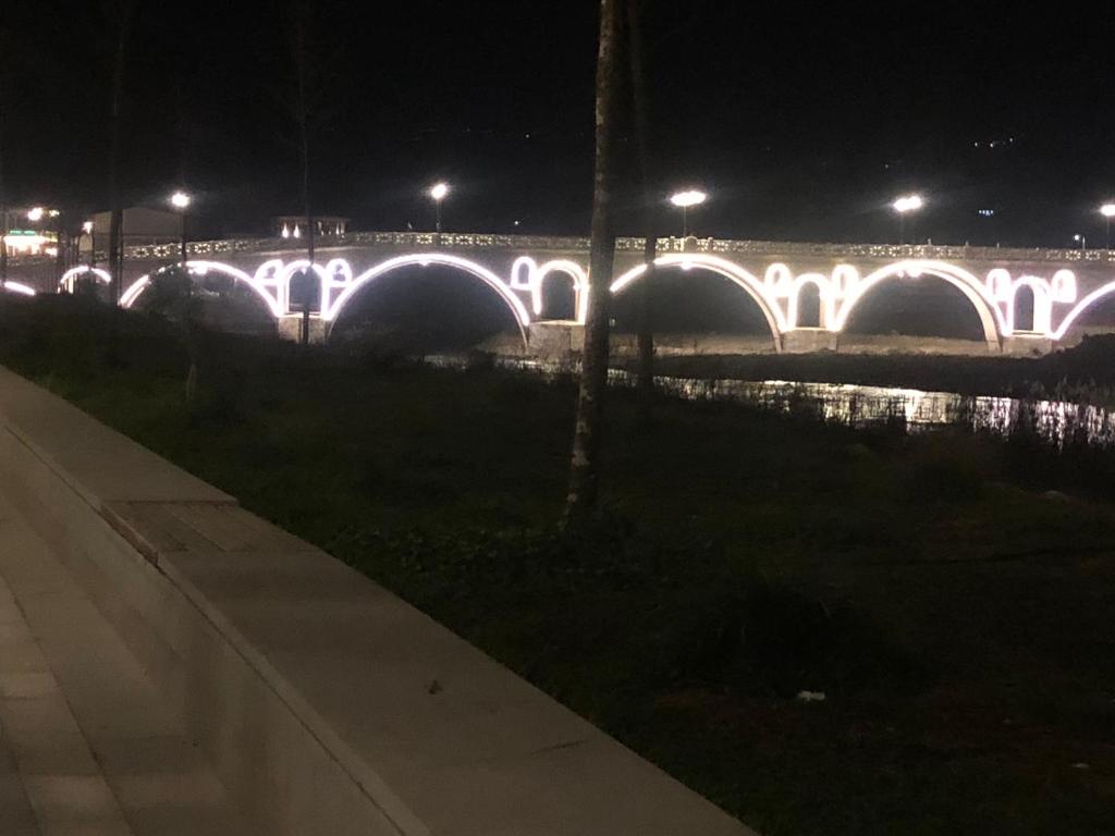 a bridge lit up at night with lights at Dhimitri's guest house in Berat