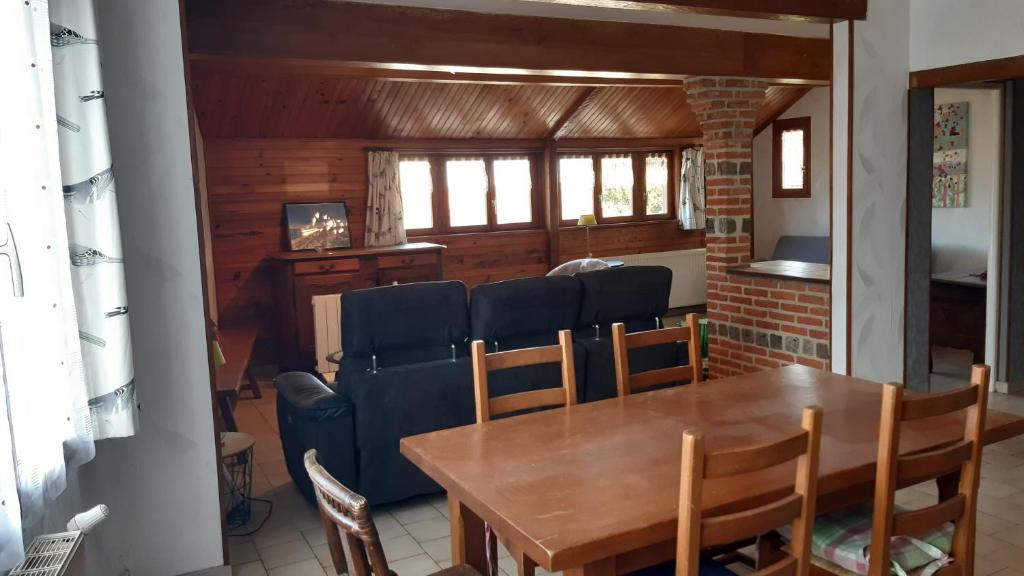 une salle à manger avec une table et des chaises en bois dans l'établissement Oiseau Bleu, à Dieppe