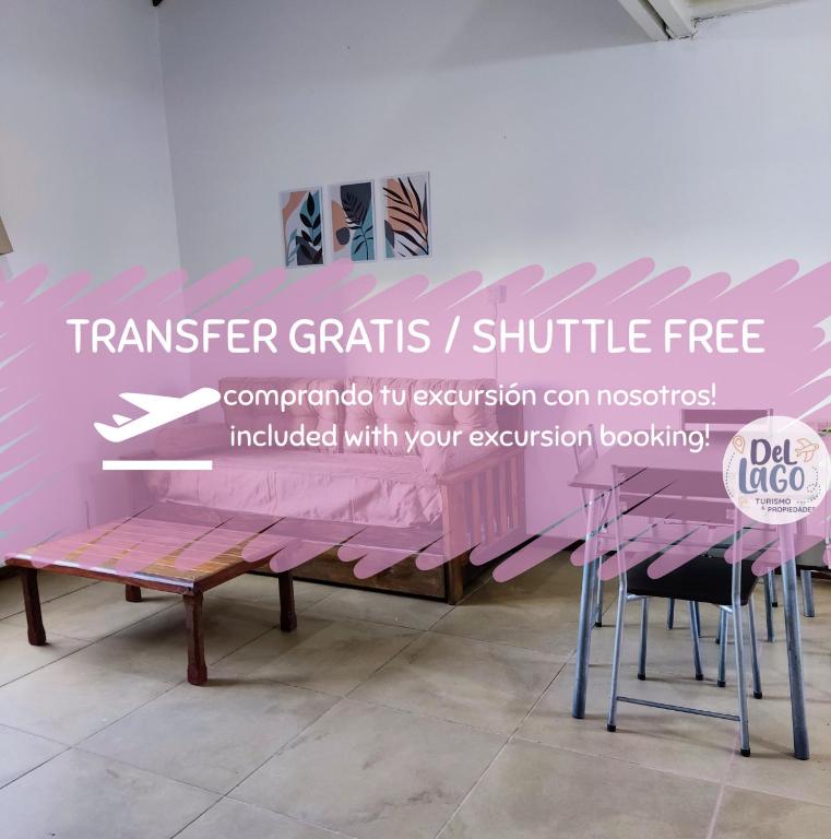 ein rosa Tisch mit Stühlen in einem Zimmer in der Unterkunft Confortable y espacioso Loft! Excelente ubicación in El Calafate