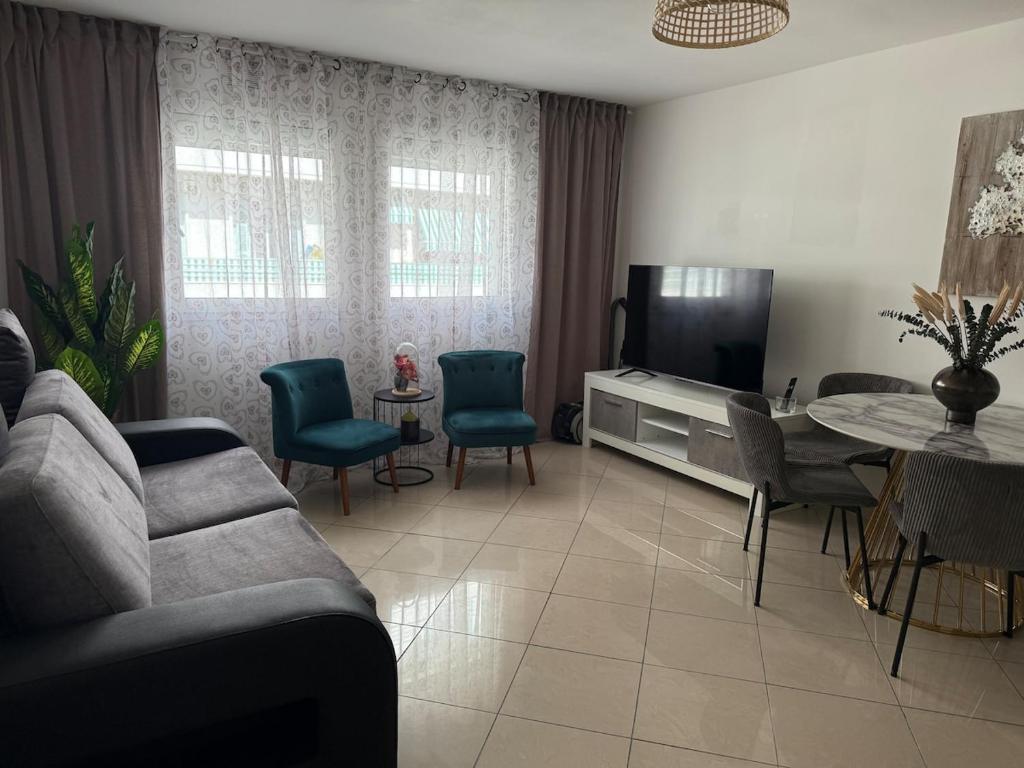 un salon avec un canapé, une télévision et une table dans l'établissement Nice apartment Promenade des Anglais à 5 minutes de la mer à pied, à Nice