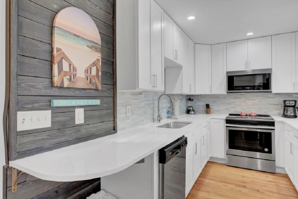 Una cocina con gabinetes blancos y una encimera blanca. en Sandcrab Court 2 by Wild Dunes, with Amenities, en Isle of Palms