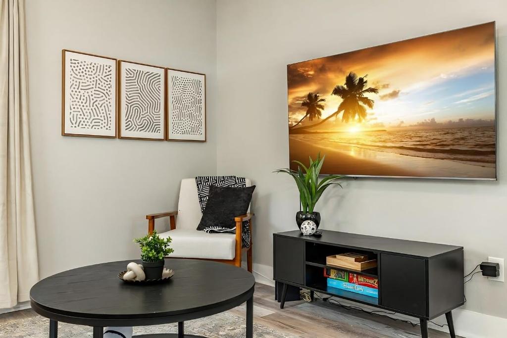 una sala de estar con una mesa y una foto en la pared en Saint Pete Hideaway Cozy Urban Escape Oasis, en San Petersburgo
