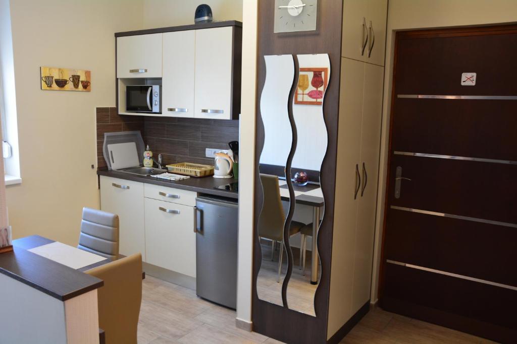 a kitchen with a refrigerator next to a kitchen counter at Bodza Apartmanok in Eger