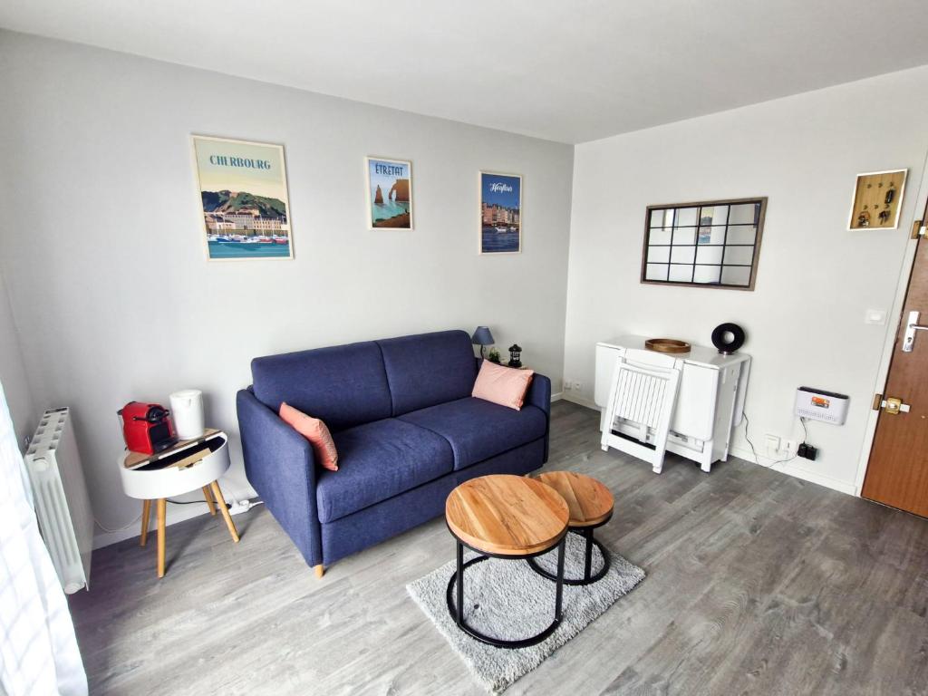 un salon avec un canapé bleu et une table dans l'établissement Duplex pour escapade en Normandie, à Merville-Franceville-Plage
